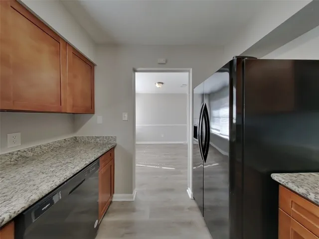 a kitchen with a granite countertop refrigerator and cabinets