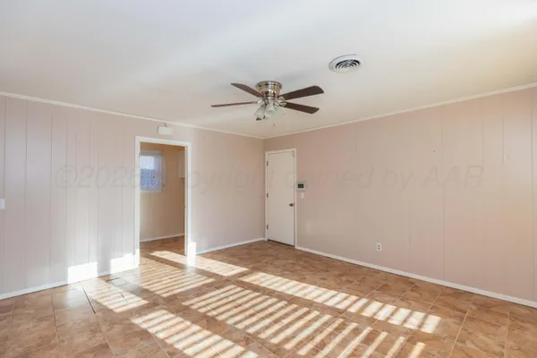 a view of a livingroom with a chandelier fan and a window