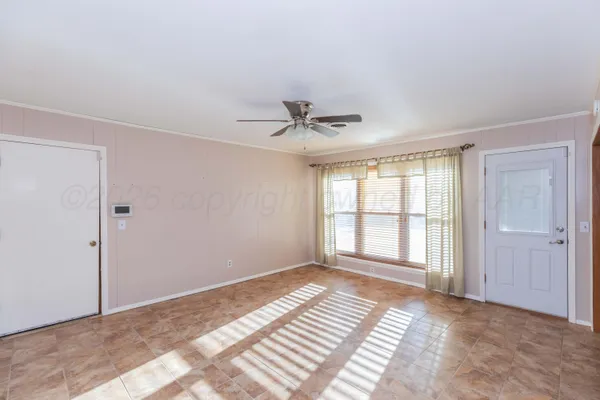a view of a livingroom with a ceiling fan and window