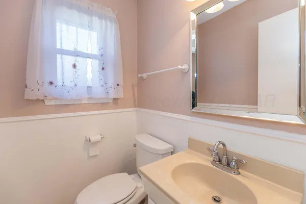 a bathroom with a sink mirror and toilet