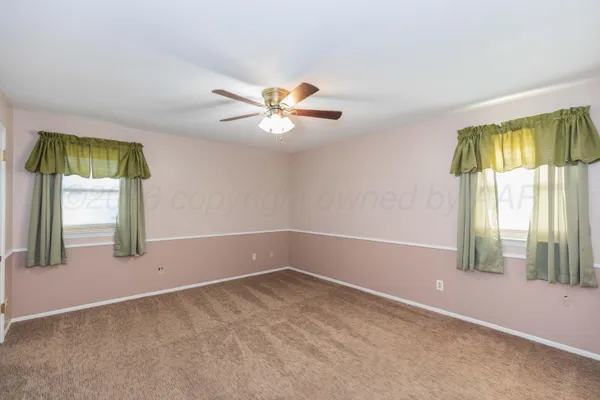 an empty room with a ceiling fan and a window
