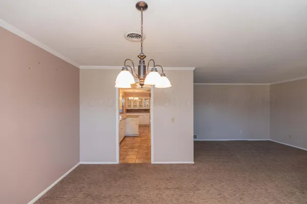 a view of a room with a hanging light and kitchen
