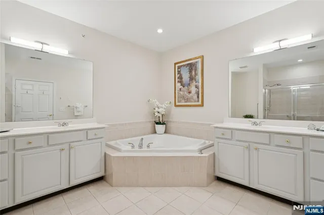 a bathroom with a tub sink and mirror