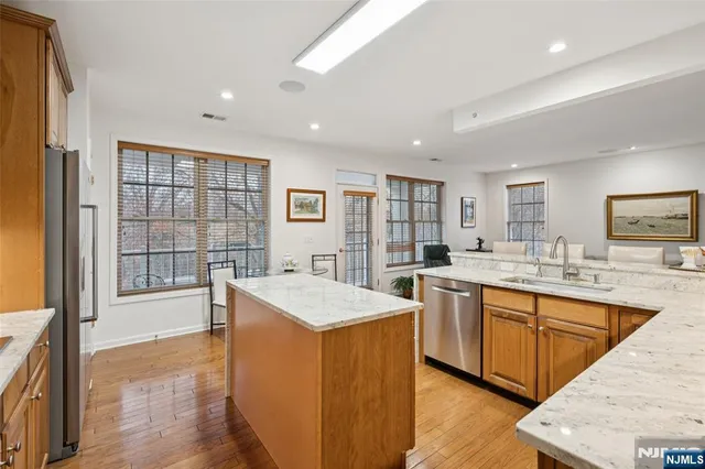 a large kitchen with kitchen island a sink stainless steel appliances and a large window