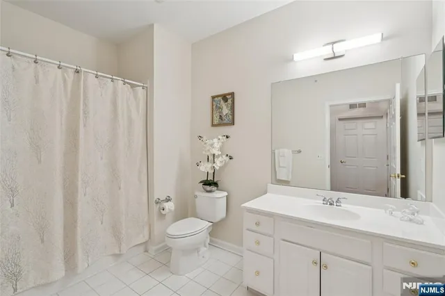 a bathroom with a granite countertop sink a toilet and a shower