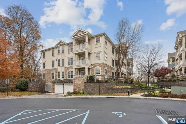 a front view of a building with lot of street and trees
