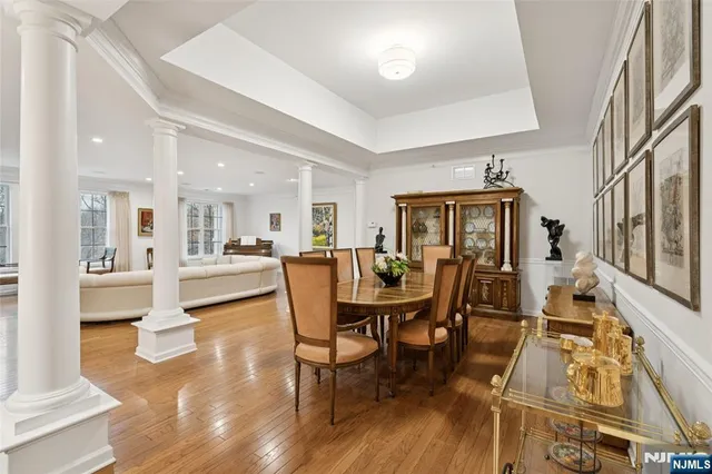 a dining room with wooden floor a chandelier a glass table and chairs