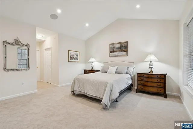 a spacious bedroom with a bed and a lamp