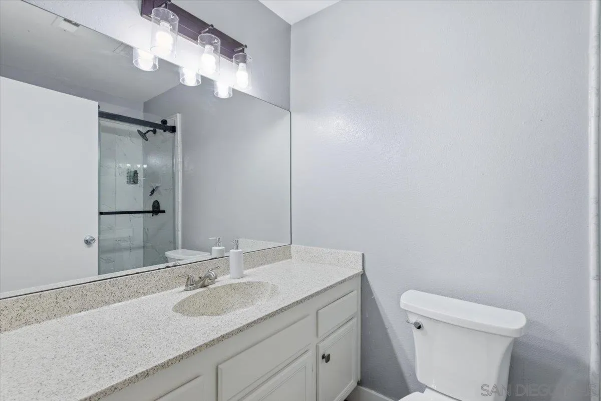 8825 Tamberly Way, Unit A Santee, CA 92071 - Photo 14 of 23 a bathroom with a sink a toilet a mirror and shower