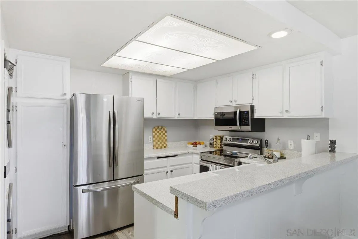 8825 Tamberly Way, Unit A Santee, CA 92071 - Photo 8 of 23 a kitchen with stainless steel appliances a refrigerator sink and microwave