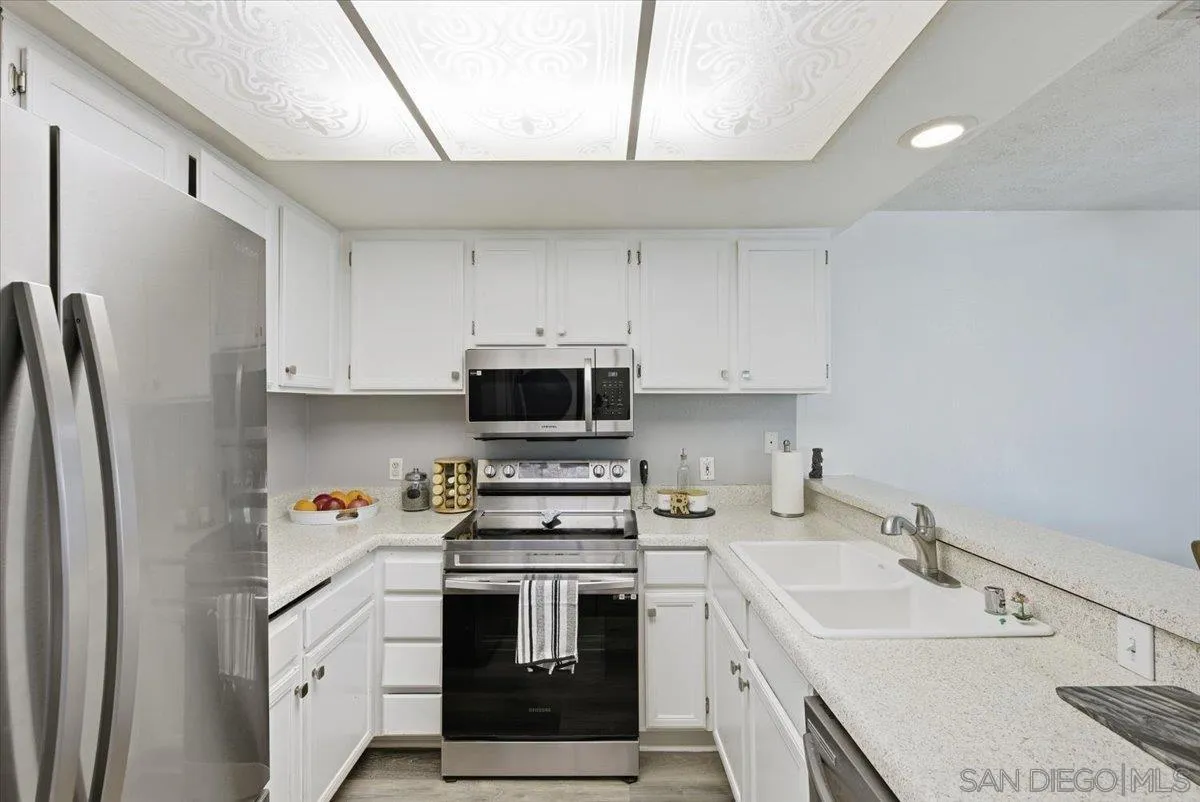 8825 Tamberly Way, Unit A Santee, CA 92071 - Photo 9 of 23 a kitchen with stainless steel appliances a sink stove refrigerator and cabinets