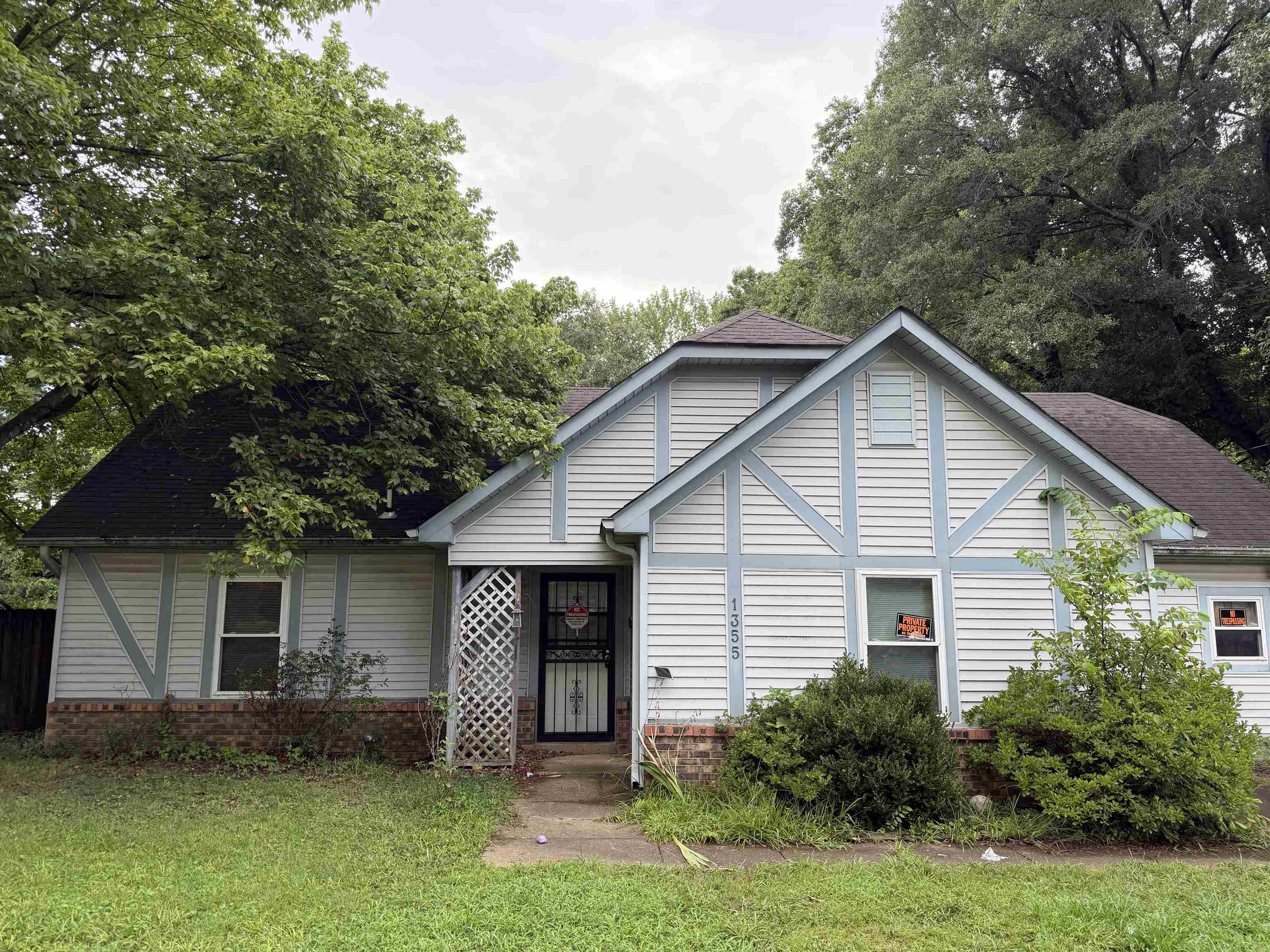 1355 Portersville Road Atoka, TN 38004 - Photo 1 of 9 Front exterior featuring siding with light blue trim accents, a dark shingle roof, and a mature tree canopy