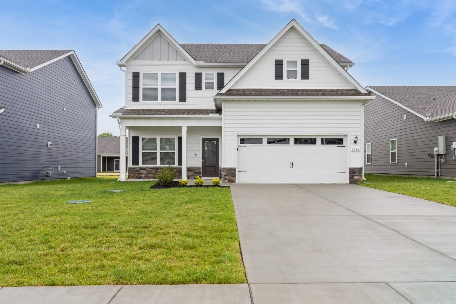 a view of a white house with a small yard and large window