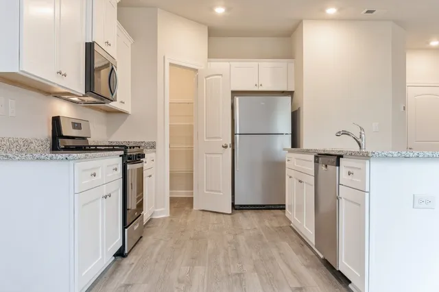 a kitchen with stainless steel appliances a refrigerator sink and cabinets