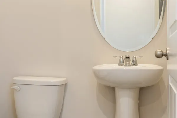a bathroom with a sink a toilet and a mirror