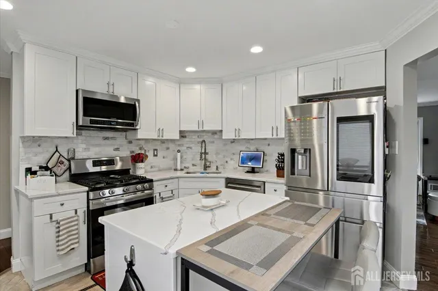 a kitchen with a refrigerator a stove a microwave and cabinets
