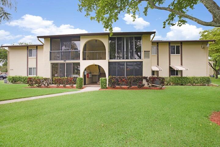 306 Pine Ridge Circle, Unit D1 Greenacres, FL 33463 - Photo 1 of 26 a front view of house with yard and outdoor seating