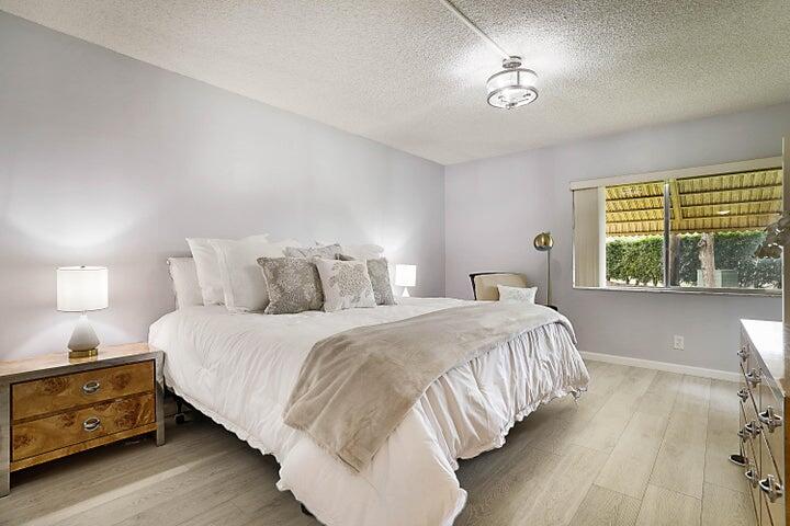 306 Pine Ridge Circle, Unit D1 Greenacres, FL 33463 - Photo 15 of 26 a bedroom with a bed and a night stand