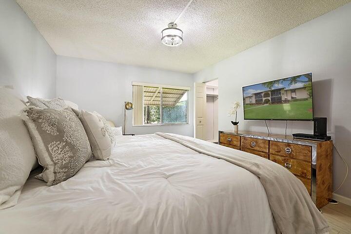 306 Pine Ridge Circle, Unit D1 Greenacres, FL 33463 - Photo 16 of 26 a bedroom with a bed and a flat screen tv