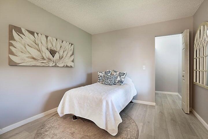 306 Pine Ridge Circle, Unit D1 Greenacres, FL 33463 - Photo 18 of 26 a bedroom with a bed and a wall painting
