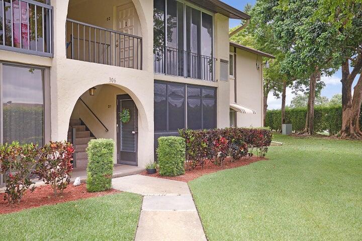 306 Pine Ridge Circle, Unit D1 Greenacres, FL 33463 - Photo 2 of 26 a front view of a house with garden