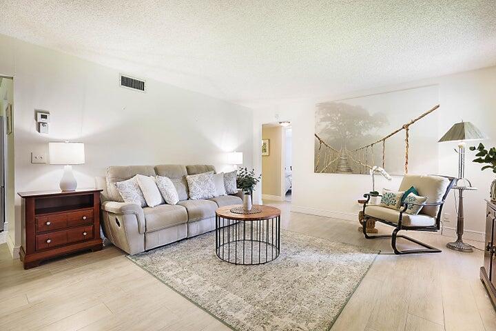 306 Pine Ridge Circle, Unit D1 Greenacres, FL 33463 - Photo 24 of 26 a living room with furniture and a lamp