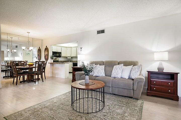306 Pine Ridge Circle, Unit D1 Greenacres, FL 33463 - Photo 3 of 26 a living room with furniture a dining table and kitchen view