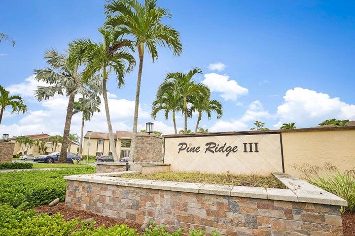 306 Pine Ridge Circle, Unit D1 Greenacres, FL 33463 - Photo 8 of 26 a sign on the side of the road