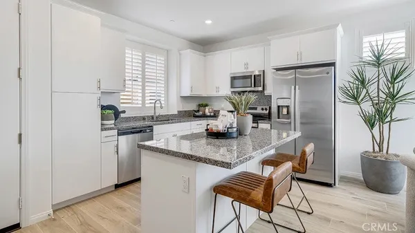 a kitchen with stainless steel appliances granite countertop a stove a sink a refrigerator and a granite counter tops