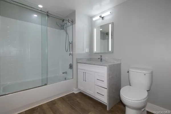 a bathroom with a granite countertop sink toilet and shower