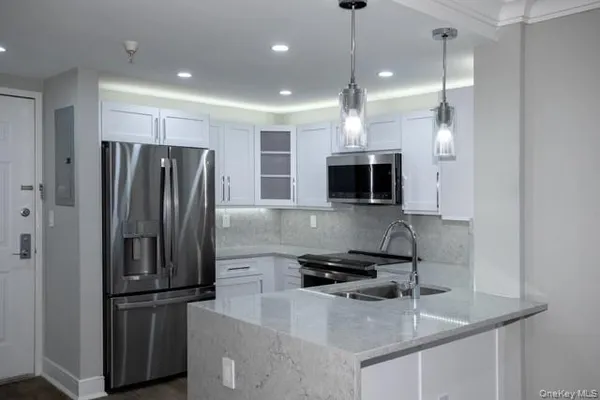 a kitchen with kitchen island a counter top space stainless steel appliances and cabinets