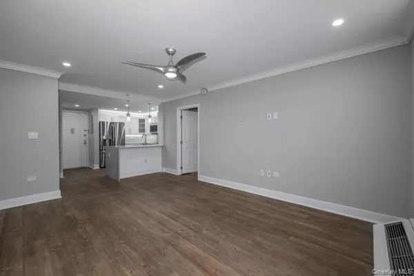 wooden floor in an empty room with a kitchen