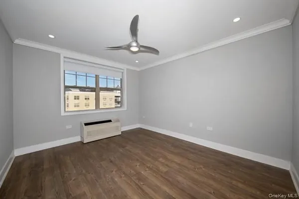 an empty room with windows and ceiling fan