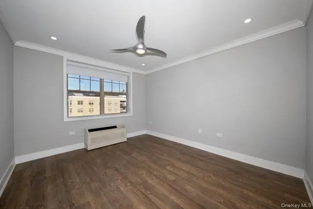 an empty room with windows and ceiling fan