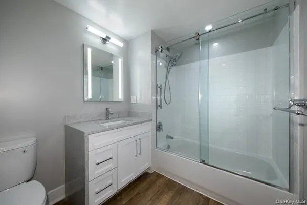 a bathroom with a granite countertop sink toilet and shower