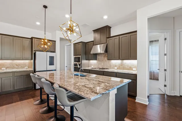 a kitchen with granite countertop kitchen island stainless steel appliances a dining table and chairs