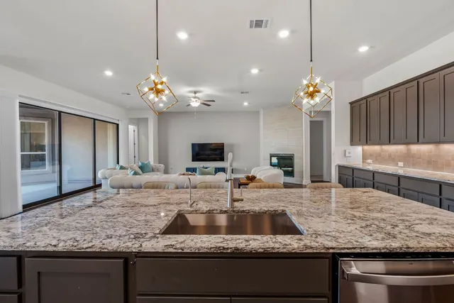 a kitchen with kitchen island granite countertop a sink and center island