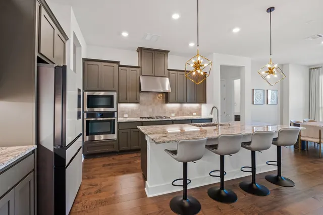 a kitchen with cabinets a counter and chairs
