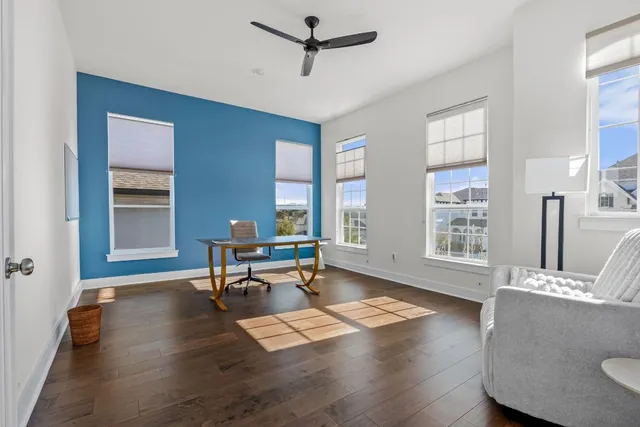 a living room with furniture a window and wooden floor