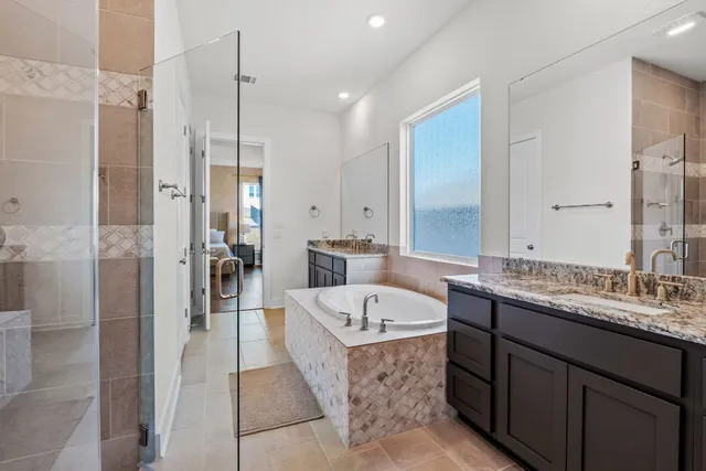 a bathroom with a large tub sink shower and mirror