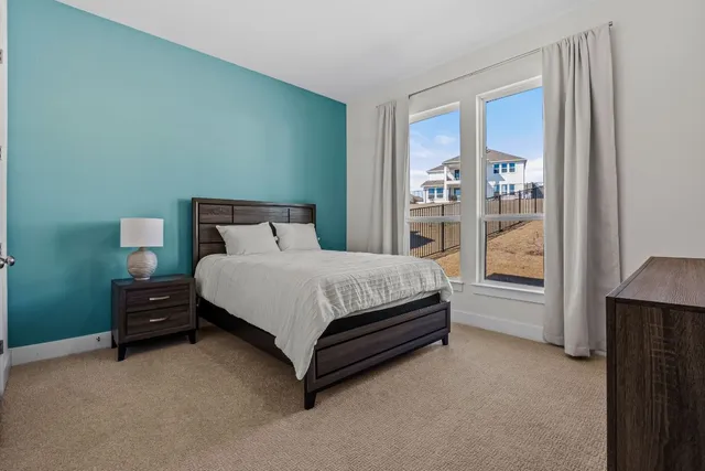 a bed sitting in a bedroom next to a window