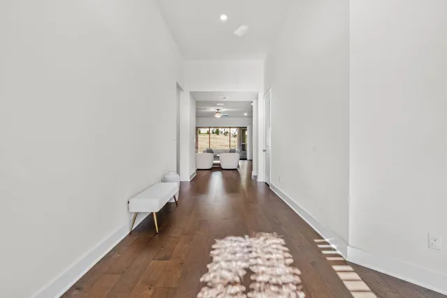 a view of a hallway with wooden floor and a rug