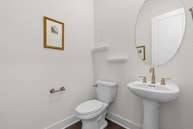 a bathroom with a sink toilet and a mirror