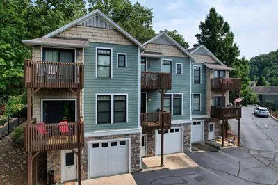 a front view of house with yard and trees in the background