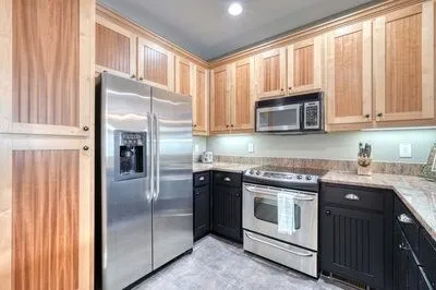 a kitchen with granite countertop a refrigerator stove and microwave