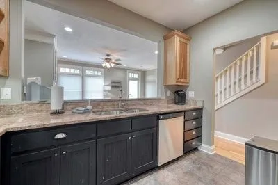 a kitchen with stainless steel appliances granite countertop a sink dishwasher a stove and a microwave oven with cabinets