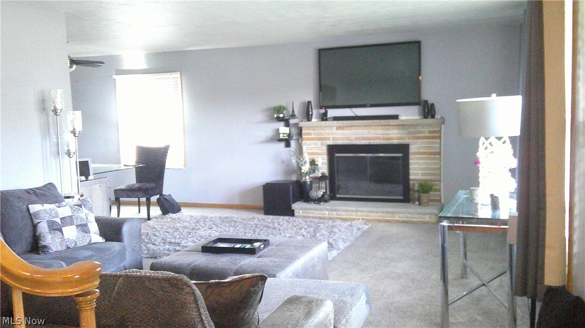 2162 Springfield Center Road Akron, OH 44312 - Photo 4 of 21 Carpeted living room featuring ceiling fan and a fireplace