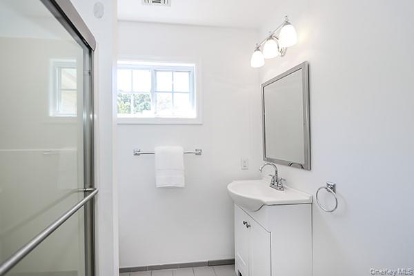 4 Spring Court Huntington, NY 11743 - Photo 22 of 38 a bathroom with a sink a mirror and a window