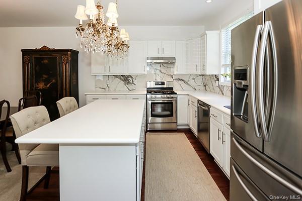 4 Spring Court Huntington, NY 11743 - Photo 9 of 38 a kitchen with stainless steel appliances a refrigerator sink and stove