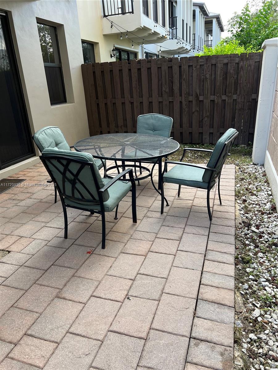 Doral Doral, FL 33178 - Photo 16 of 32 a view of a patio with table and chairs with wooden floor and fence